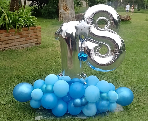 Bouquet globos plateados número 18, sobre base de globos opacos celetes de distinta graduación.